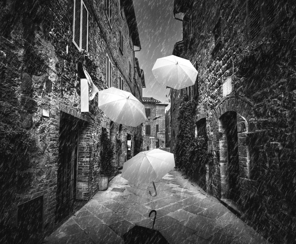 Flying black white umbrellas in street in Tuscany Canvas Wall Art Picture Print